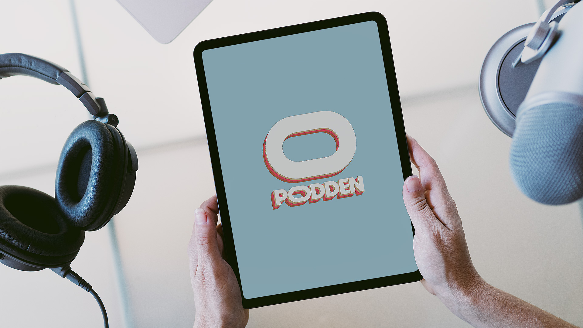 Händer som håller tablet med Opoddens logga.